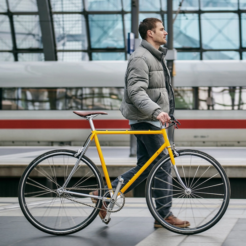 Cykel eller tog? En rejsende skubber en cykel over perronen på Berlins hovedbanegård. Nu stiger prisen på togbilletter. (Foto: Deutsche Bahn)